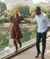 Model is wearing UNTUCKit Short Sleeve Fall Floral Midi Alix Dress in Black Orange Pink Floral Print.