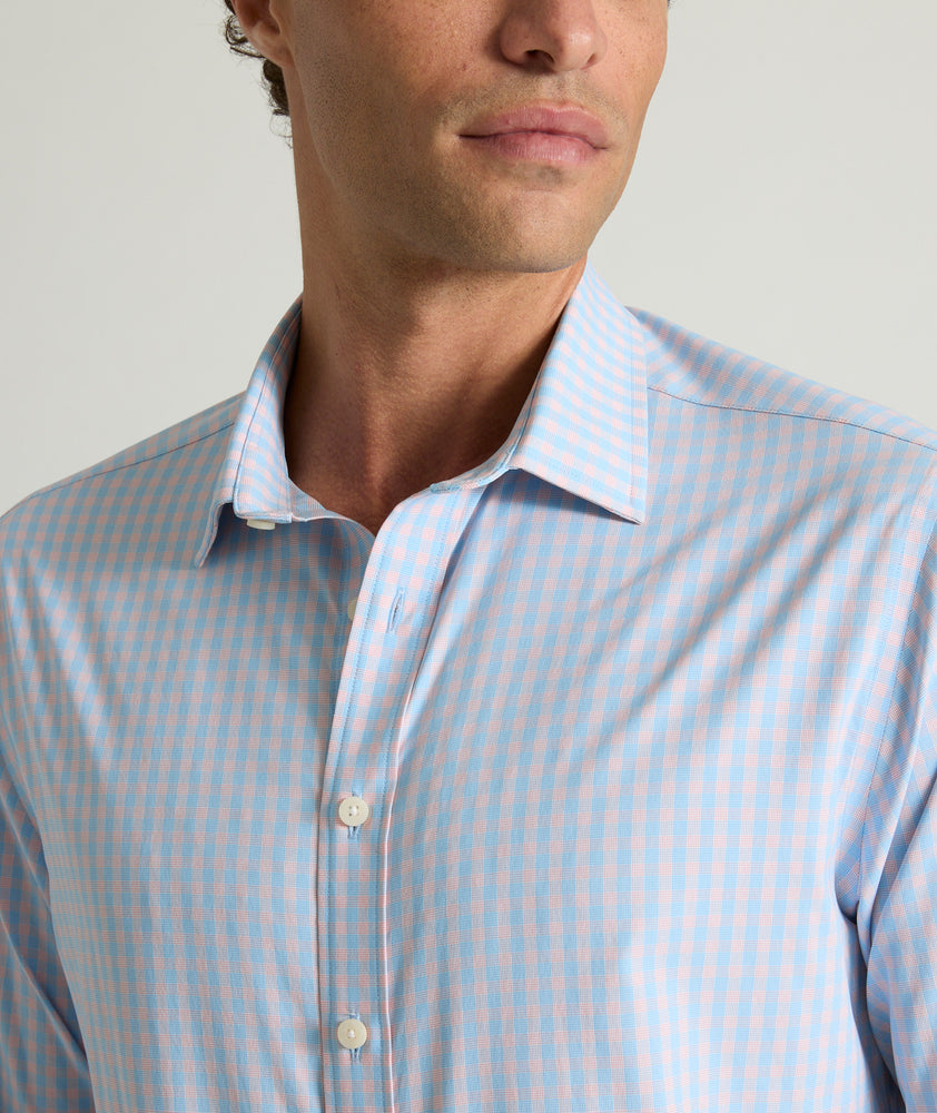 Model is wearing UNTUCKit Benson shirt in pink and blue gingham. 