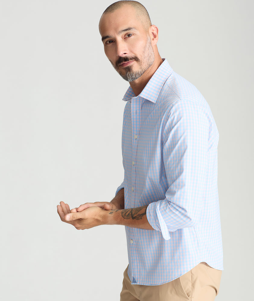 Model is wearing UNTUCKit Benson shirt in pink and blue gingham. 