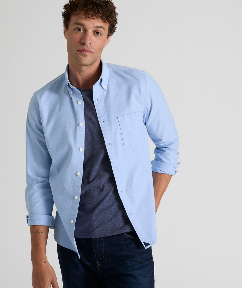 Model is wearing UNTUCKit Bridges shirt in ragatta blue oxford stretch.