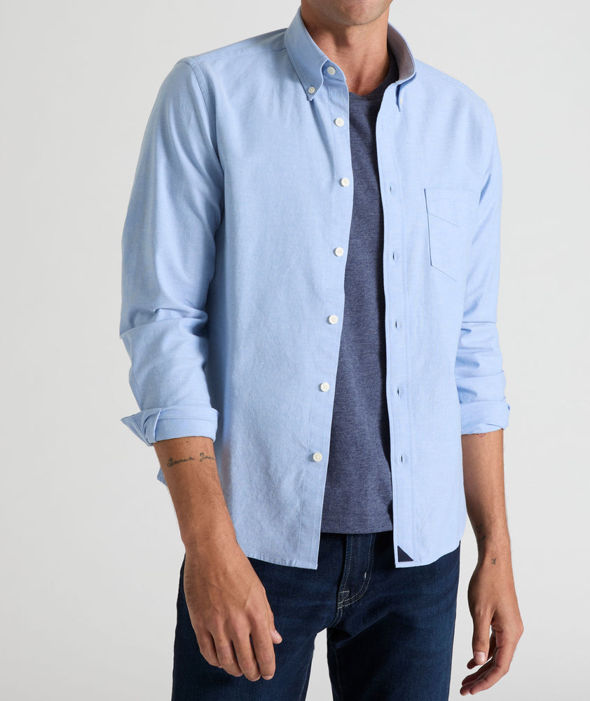 Model is wearing UNTUCKit Bridges shirt in ragatta blue oxford stretch.