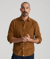 Model is wearing UNTUCKit Caprone Cord Shirt in golden brown.