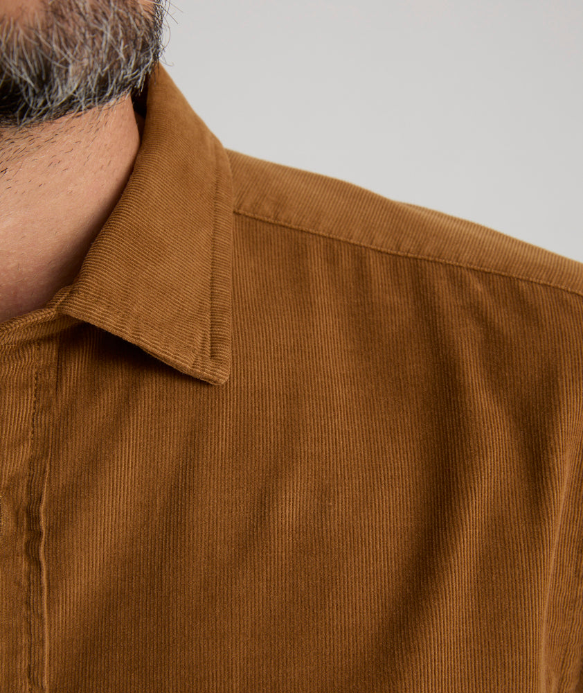 Model is wearing UNTUCKit Caprone Cord Shirt in golden brown.