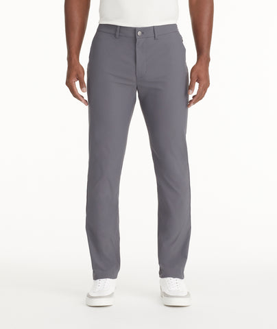 Model is wearing UNTUCKit Traveler Tech Pants in gray. 