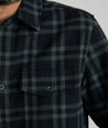 Model is wearing UNTUCKit Chaselo in bark green and black check over shirt.