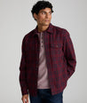 Model is wearing UNTUCKit Chaselo in bark maroon and black check over shirt.