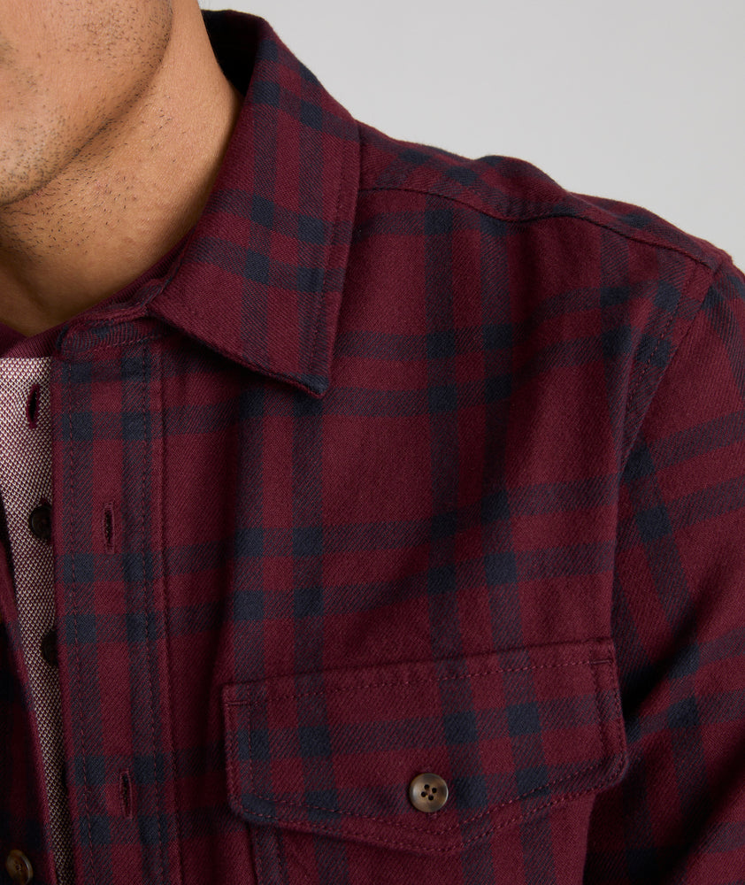 Model is wearing UNTUCKit Chaselo in bark maroon and black check over shirt.