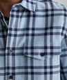 Model is wearing UNTUCKit Chaselo in light blue and navy check over shirt.