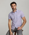 Model is wearing UNTUCKit Crofton shirt in performance purple print. 