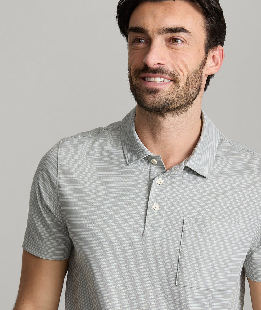 Model is wearing UNTUCKit Gilbert Striped Performance Polo in Castor Gray