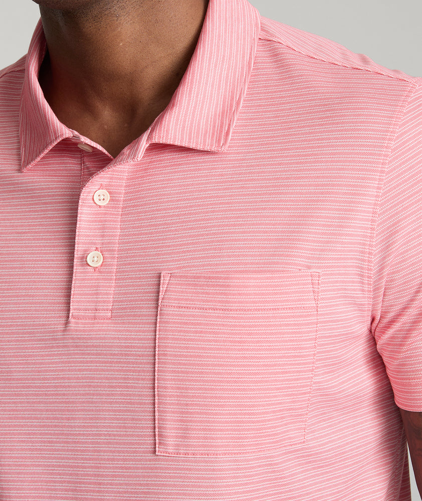 Model is wearing UNTUCKit Gilbert Striped Performance Polo in Rose of Sharon.