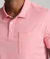 Model is wearing UNTUCKit Gilbert Striped Performance Polo in Rose of Sharon.