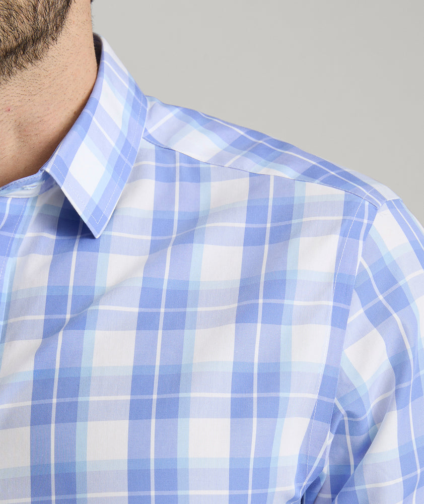 Model is wearing UNTUCKit Gillingham wrinkle-free shirt in blue. 