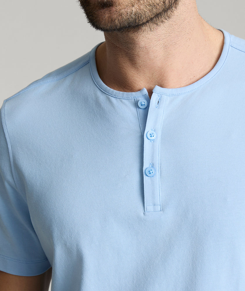 Model is wearing UNTUCKit glera tencel Placid Blue henley. 