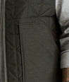 Model is wearing UNTUCKit Harper vest in dark gray/green.. 