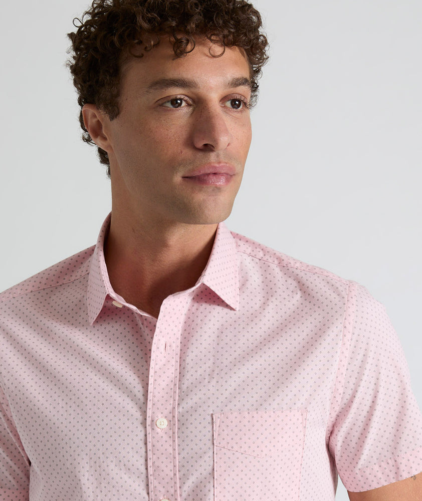 Model is wearing UNTUCKit Ingram short sleeve shirt in pink mini circle print. 