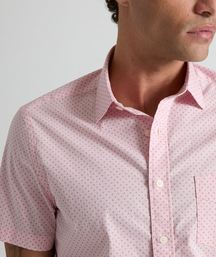 Model is wearing UNTUCKit Ingram short sleeve shirt in pink mini circle print. 