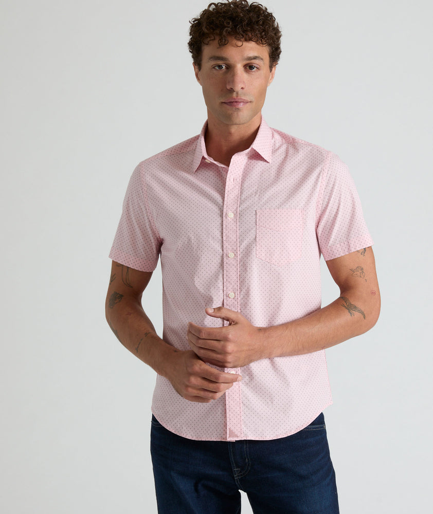 Model is wearing UNTUCKit Ingram short sleeve shirt in pink mini circle print. 