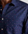 Model is wearing UNTUCKit Kipling shirt in navy with white and red triangles. 