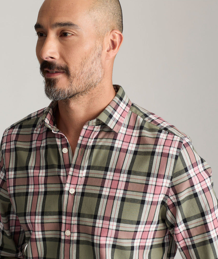 Model is wearing UNTUCKit Larson flannel in green grounded peach plaid. 