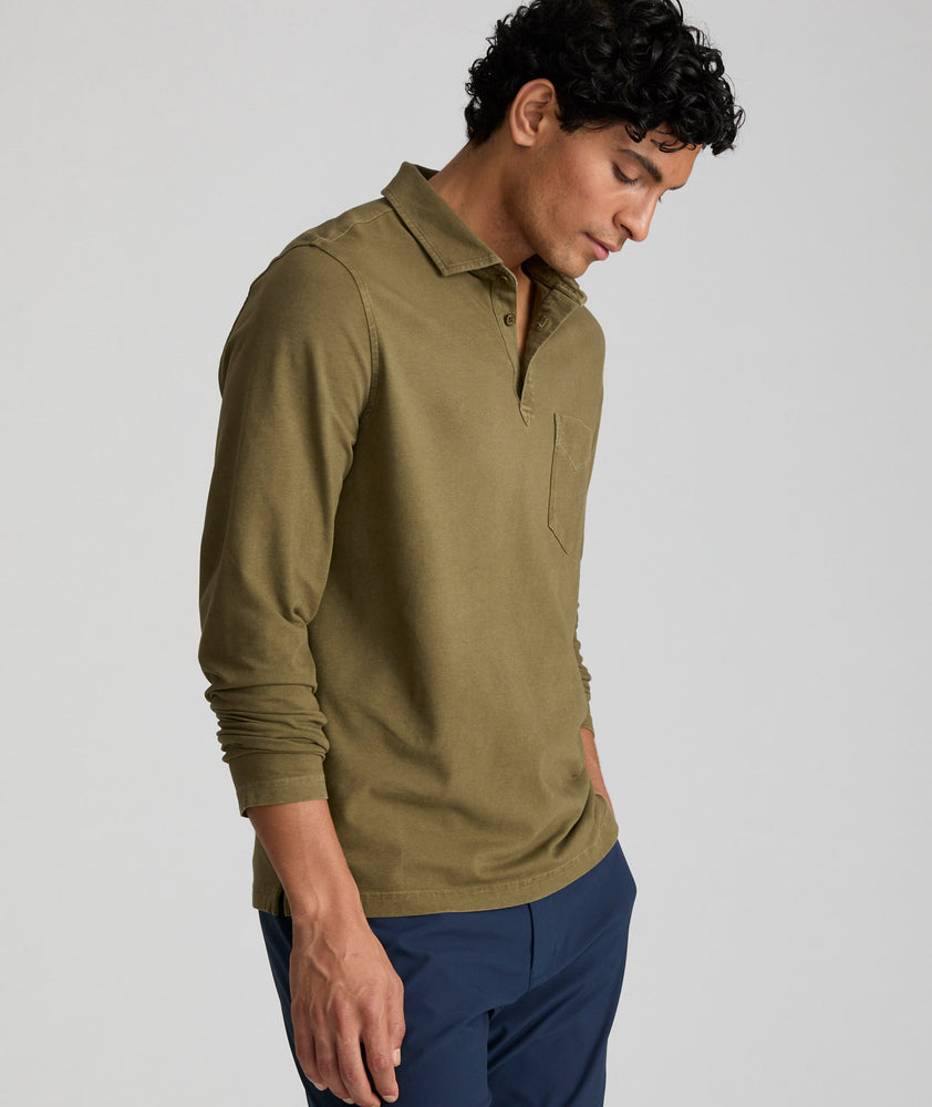 Model is wearing UNTUCKit Mays garment dyed long sleeve polo in dark olive. 