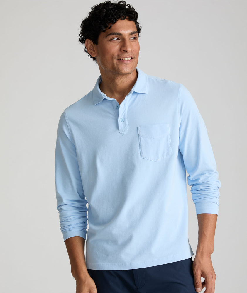 Model is wearing UNTUCKit long sleeve mays garment dyed polo in blue bell. 