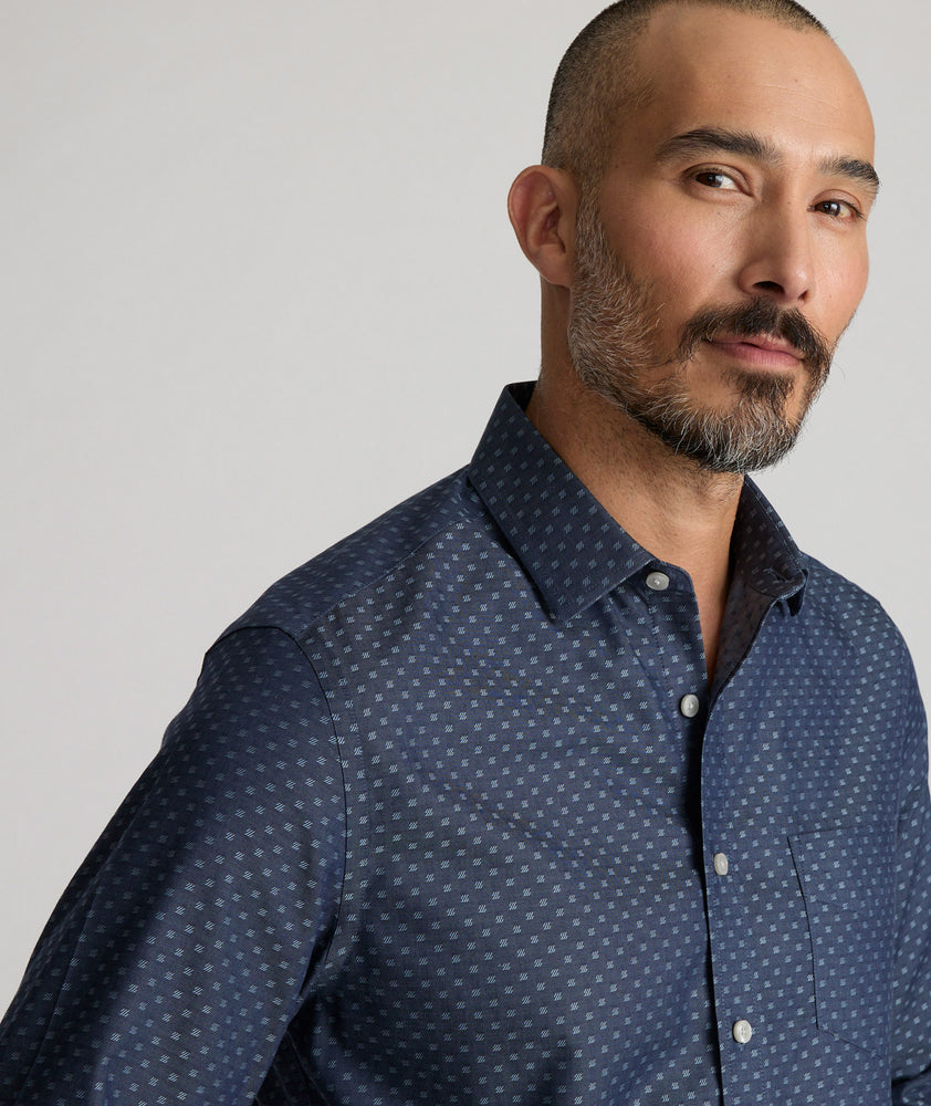 Model is wearing UNTUCKit Mcbride Wrinkle-free shirt in printed chambray. 