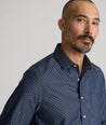 Model is wearing UNTUCKit Mcbride Wrinkle-free shirt in printed chambray. 