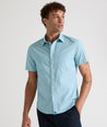 Model is wearing UNTUCKit Mccoy cotton short sleeve shirt in teal grocircle print