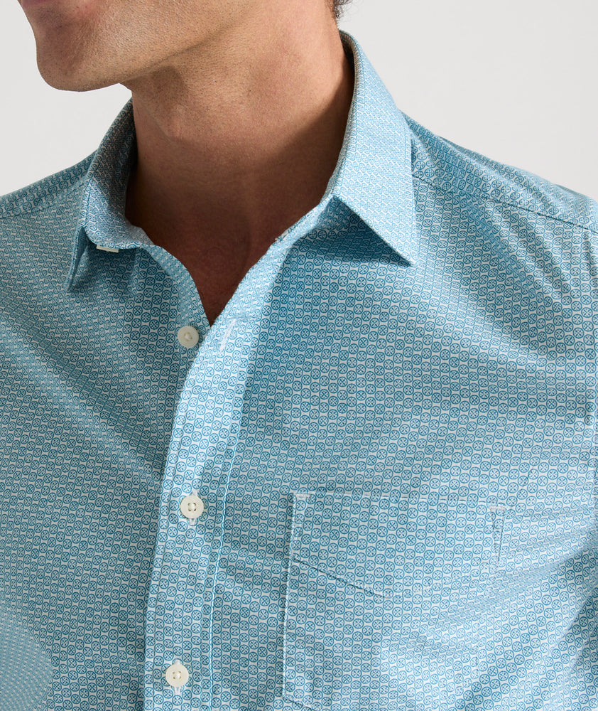 Model is wearing UNTUCKit Mccoy cotton short sleeve shirt in teal grocircle print.