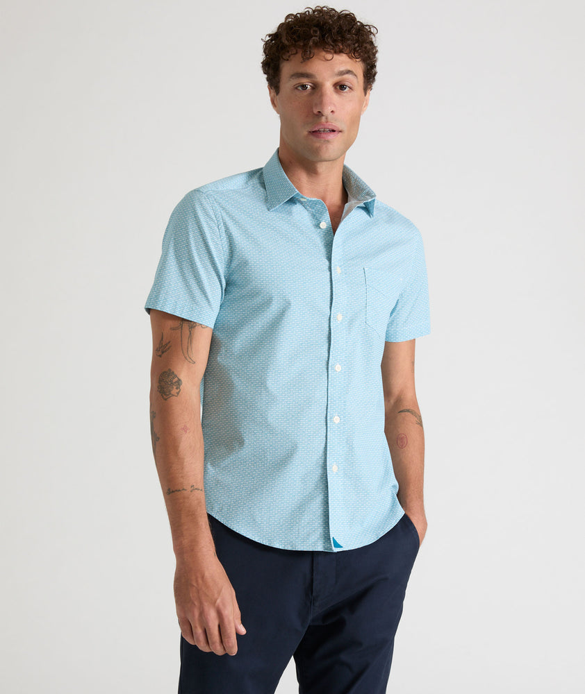 Model is wearing UNTUCKit Mccoy cotton short sleeve shirt in teal grocircle print