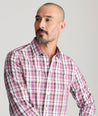 Model is wearing UNTUCKit parrish wrinkle free white grounded maroon plaid shirt. 