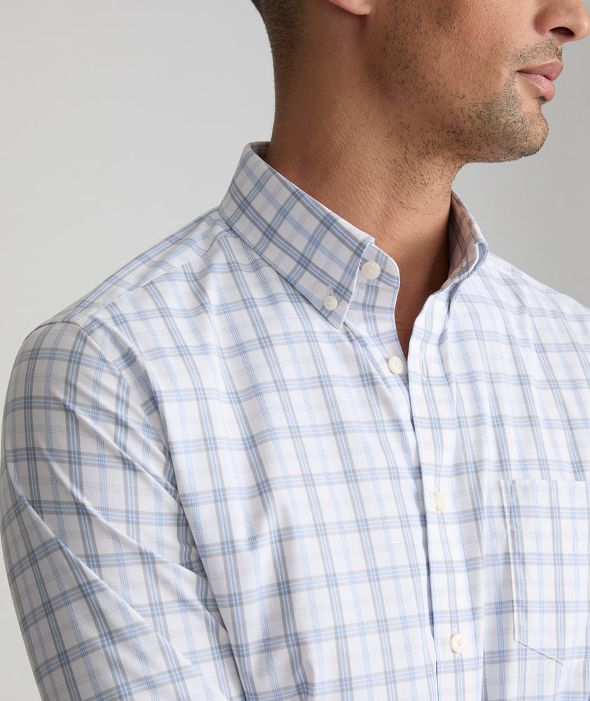 Model is wearing UNTUCKit Phillips performance shirt in white grounded with light blue and gray check. 