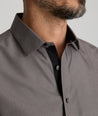 Model is wearing UNTUCKit Ribinson wrinkle-free shirt in solid gray with contrast cuff. 