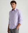 Model is wearing UNTUCKit Travelers shirt in purple tiny gingham. 