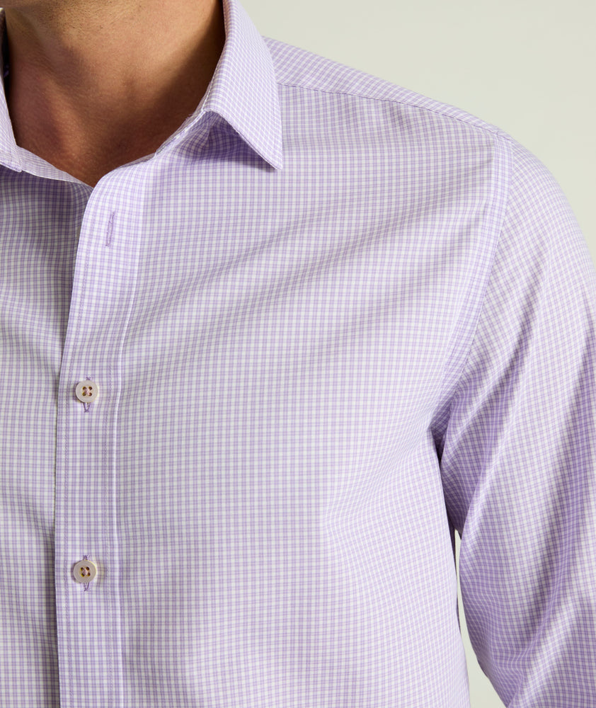 Model is wearing UNTUCKit Travelers shirt in purple tiny gingham. 