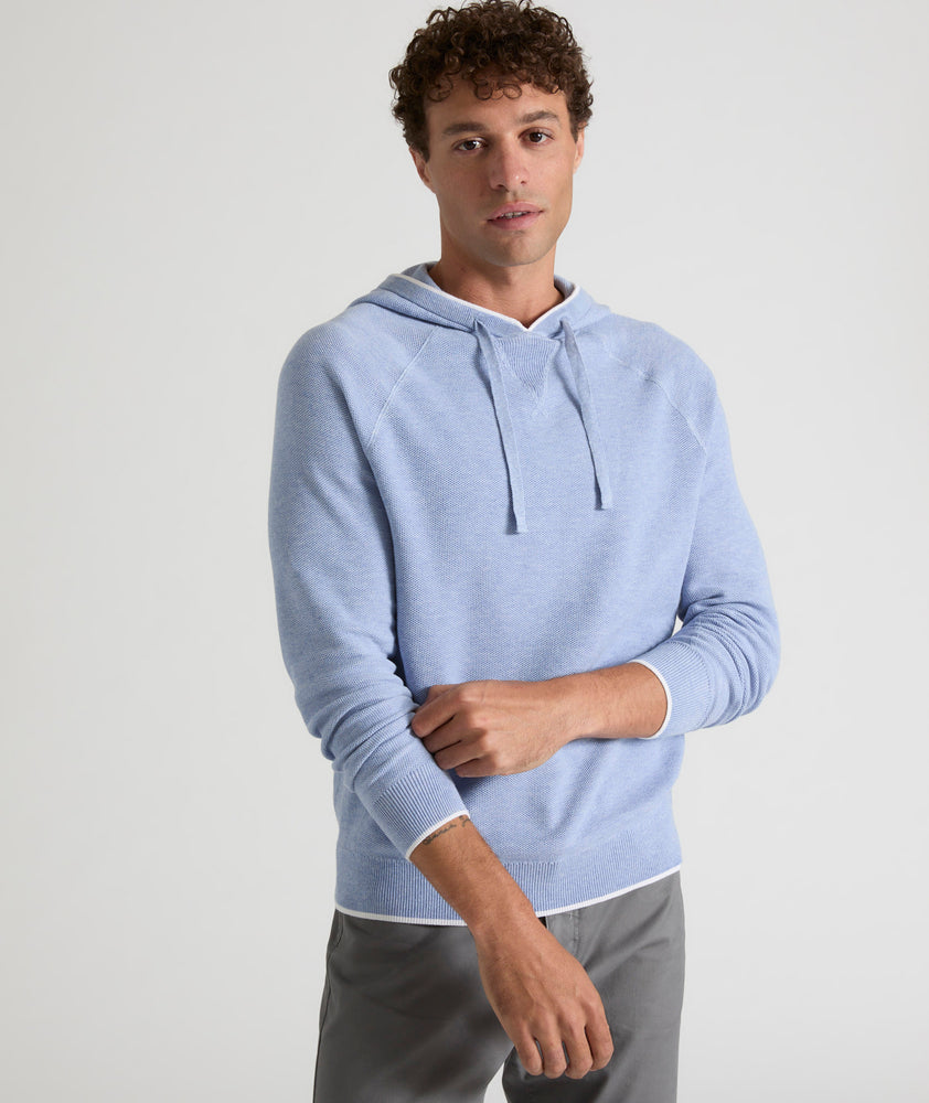 Model is wearing UNTUCKit Walcott cotton hoodie in heather blue. 