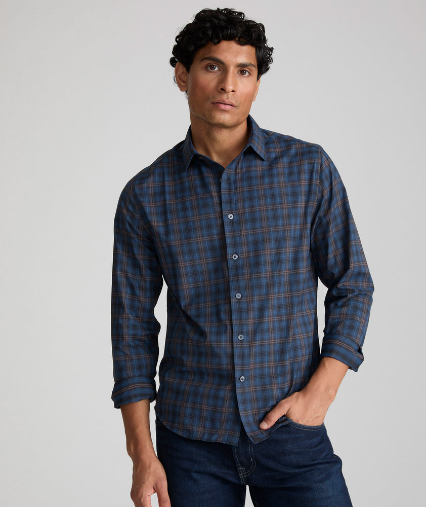 Model is wearing UNTUCKit Welch button down in bark blue with brown plaid. 