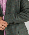 Model is wearing UNTUCKit Italian Wool Windsteig Sport Coat in Olive & Multicolor Windowpane.